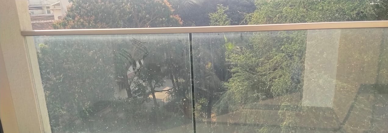 Balcony glass, paint spatter and dust removed — before cleaning